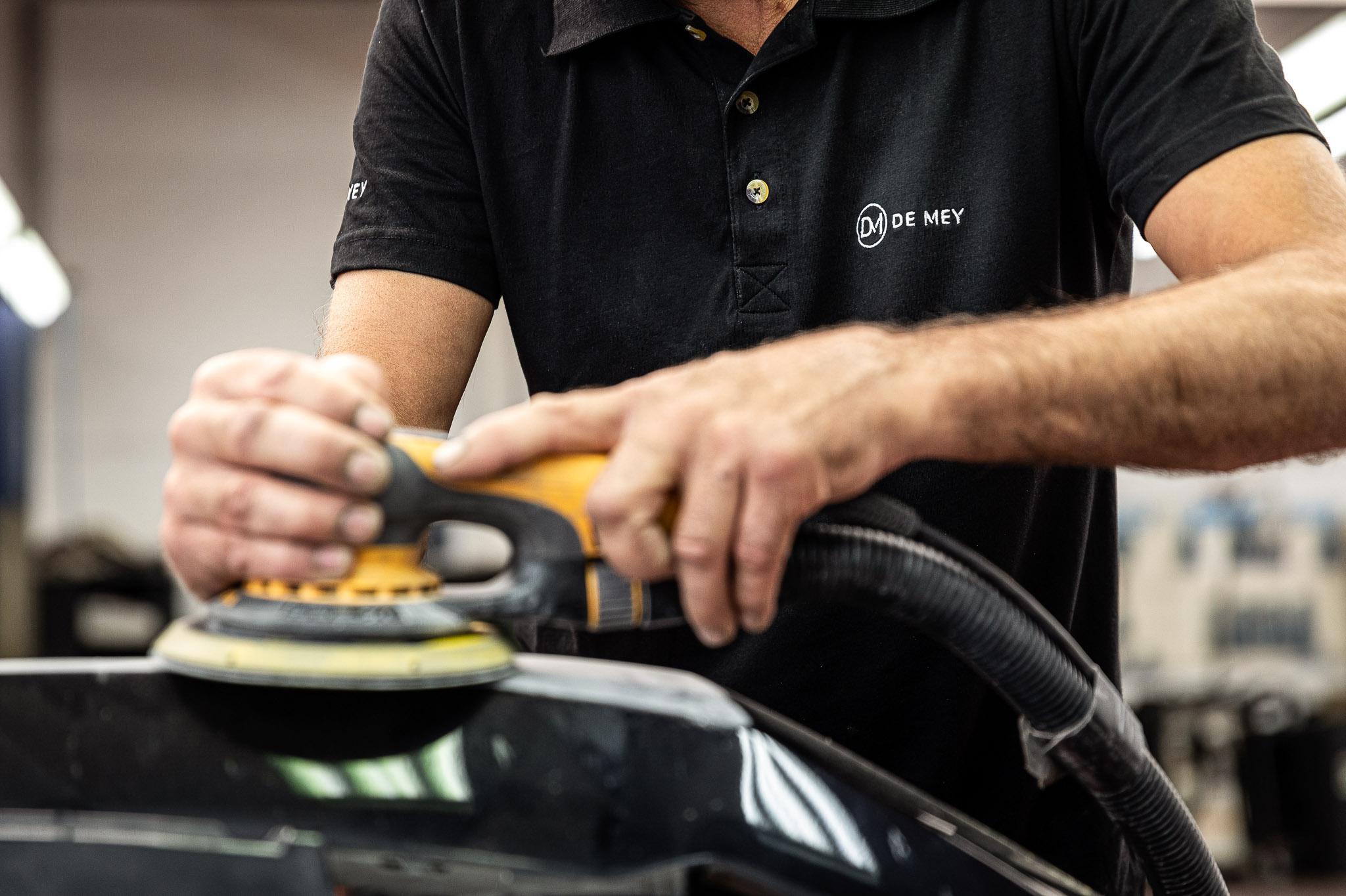 Wagen die gepolierd wordt door een medewerker van garage De Mey