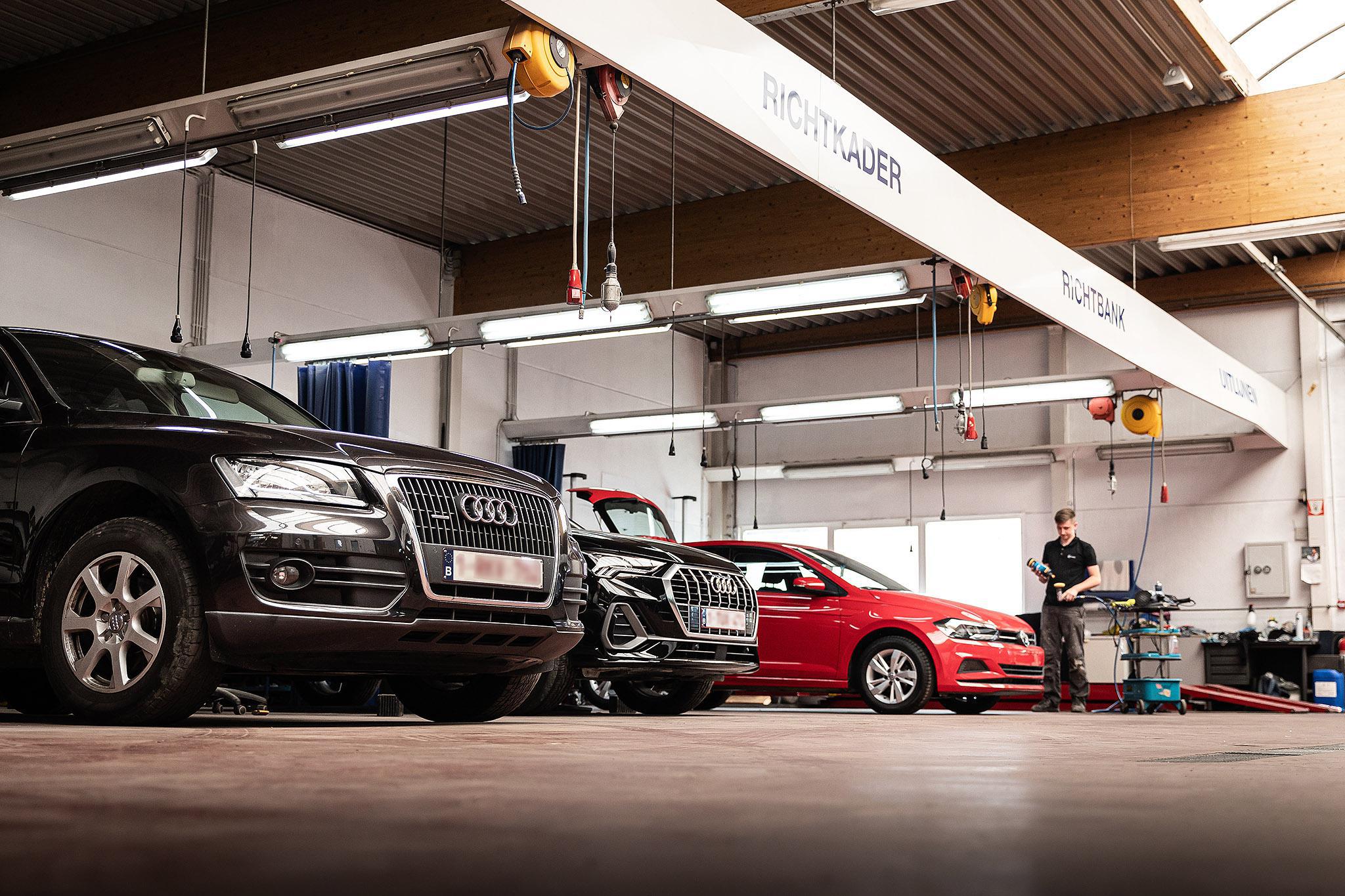 Verschillende wagens in de werkplaats van garage De Mey